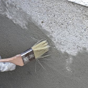 Skader i sokkelpuds: Børst langs kanterne af reparationen med en våd pensel Skader i sokkelpuds: Børst langs kanterne af reparationen med en våd pensel